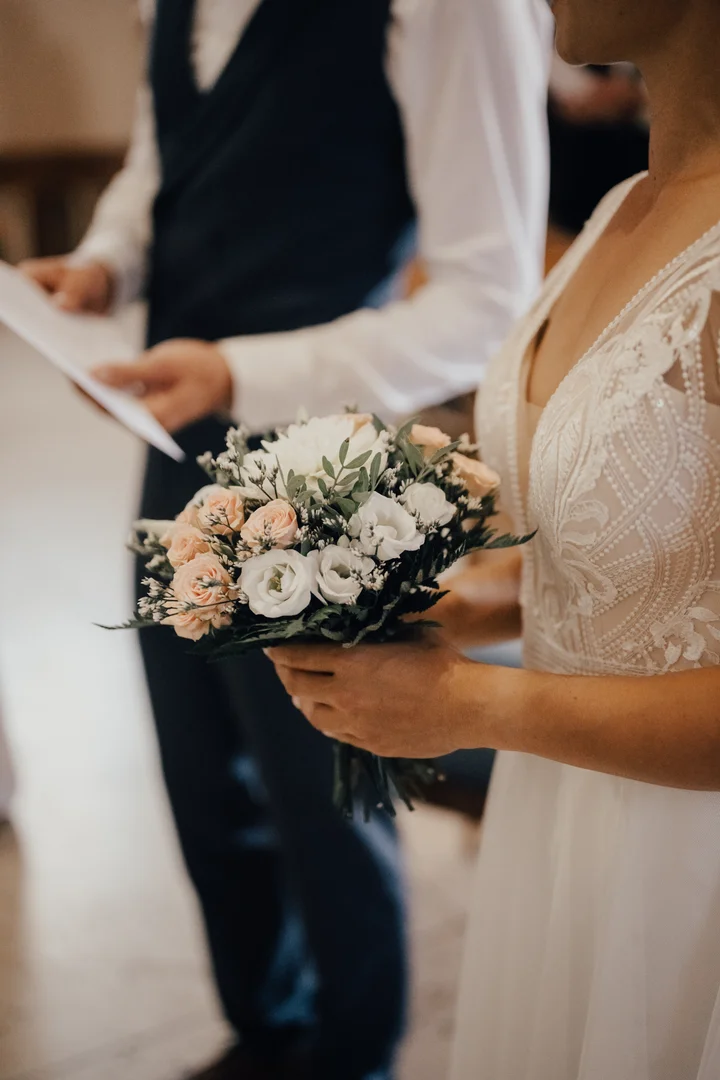 Bouquet de mariée romantique aux tons pastel (pêche, blanc) et eucalyptus, tenu par la mariée lors de la cérémonie de mariage. Compositions florales sur-mesure pour mariages en Touraine et Châteaux de la Loire par A Sparkling Moment.