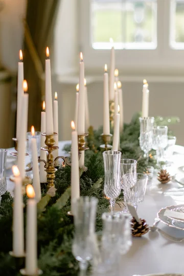 Décoration florale de table mariage hivernal, chemin de table en sapin et bougies blanches, Château de Milly, Touraine.