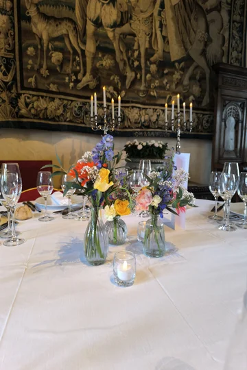 Décoration florale de table pour dîner de gala corporate, centres de table colorés en soliflores, candélabres d'argent, Château d'Amboise.